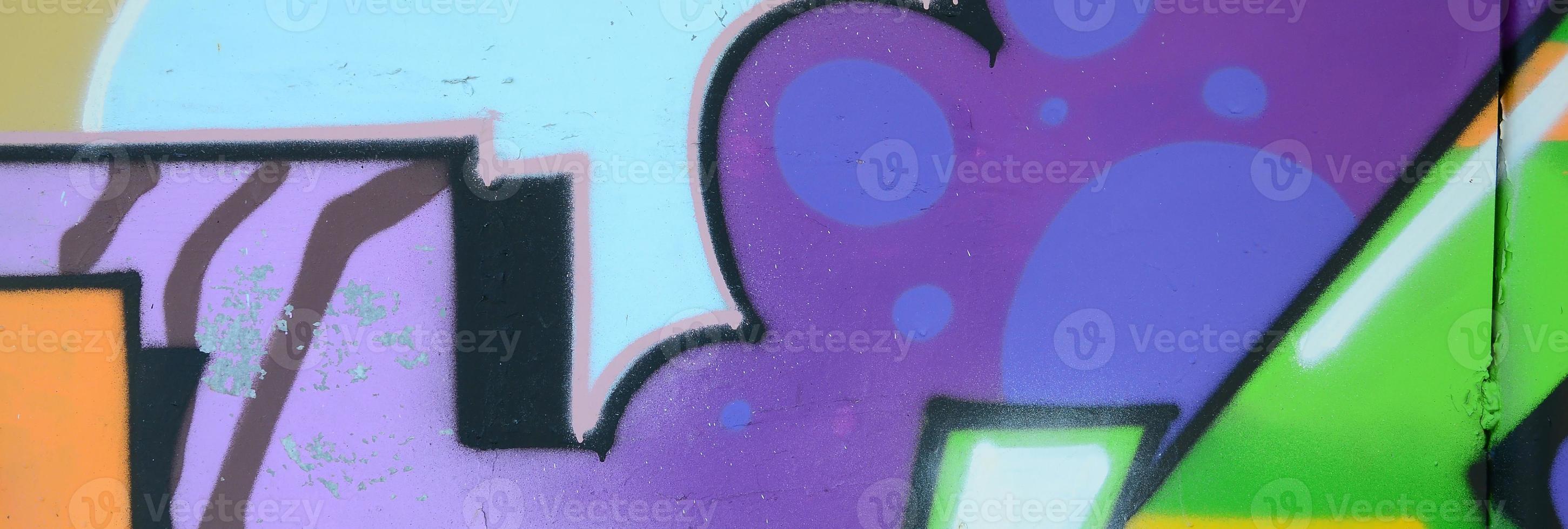 Fragment of graffiti drawings. The old wall decorated with paint stains in the style of street art culture. Multicolored background texture photo