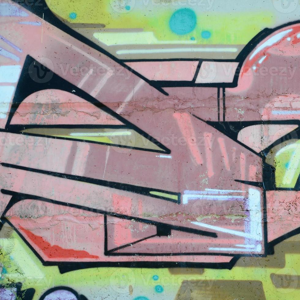 Fragment of graffiti drawings. The old wall decorated with paint stains in the style of street art culture. Colored background texture in warm tones photo