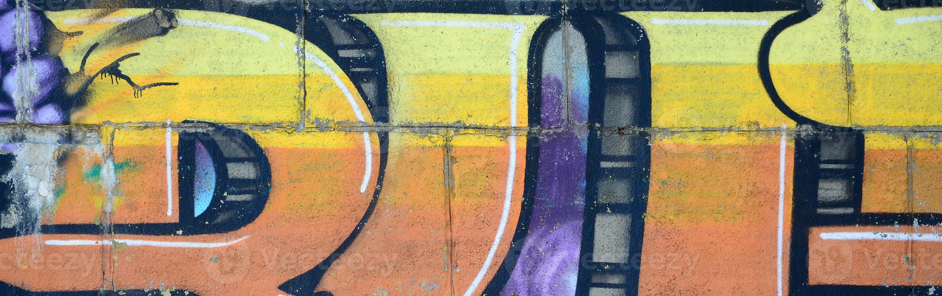Fragment of graffiti drawings. The old wall decorated with paint stains in the style of street art culture. Colored background texture in warm tones photo