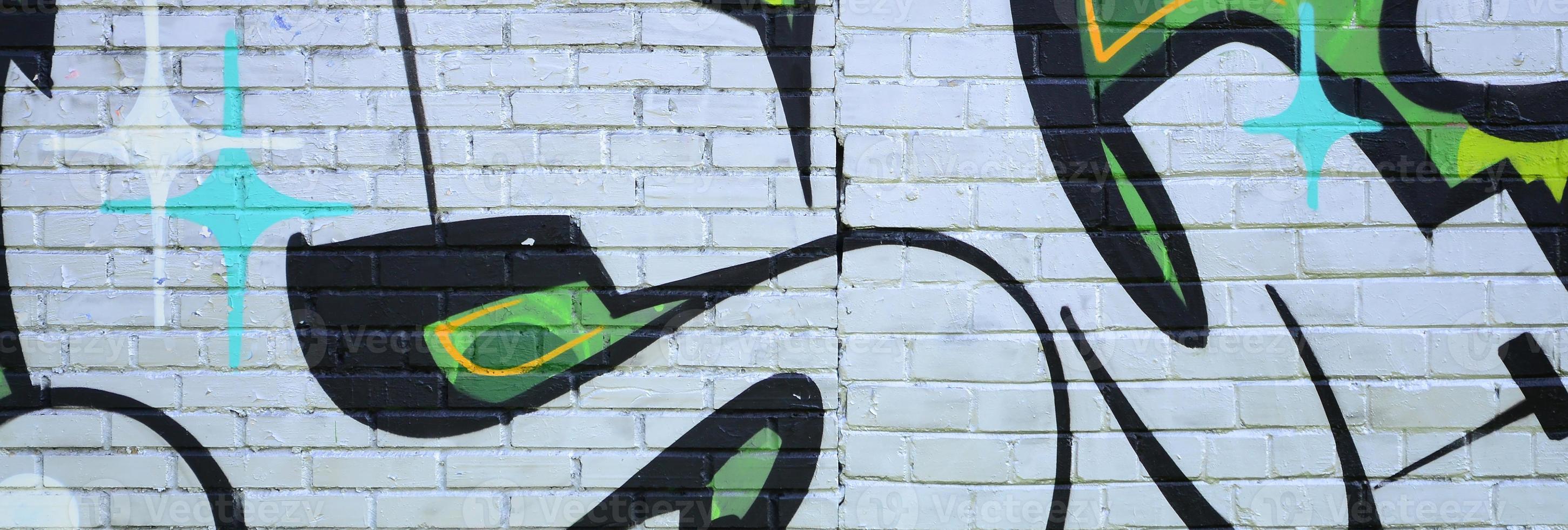 Fragment of graffiti drawings. The old wall decorated with paint stains in the style of street art culture. Colored background texture in green tones photo
