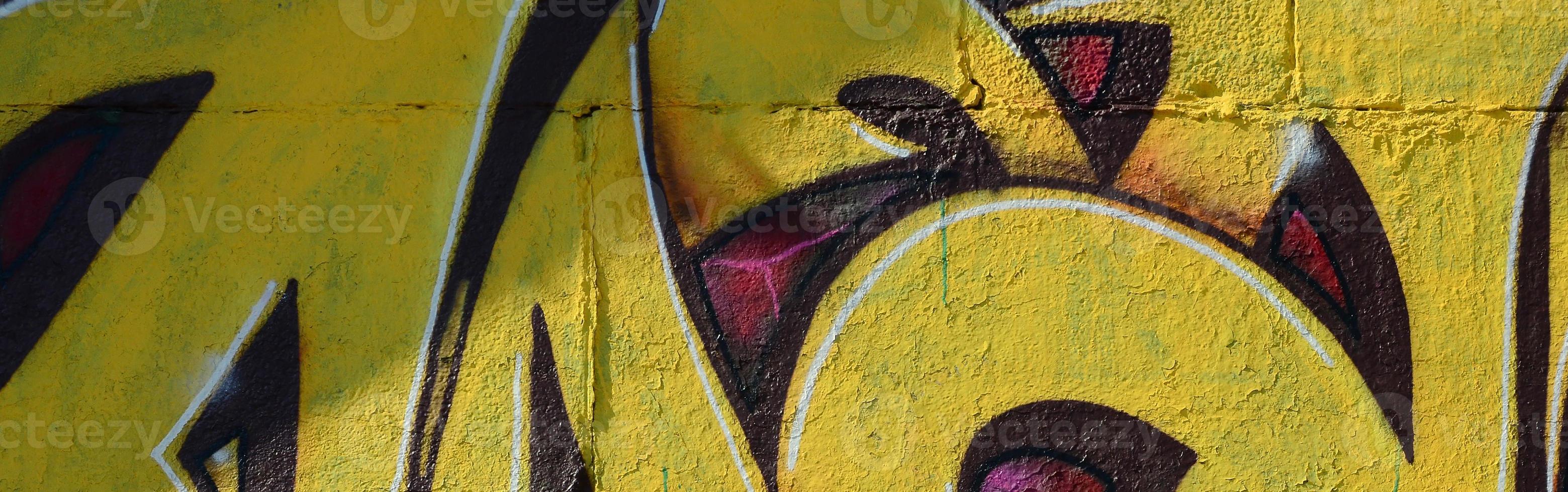 Fragment of graffiti drawings. The old wall decorated with paint stains in the style of street art culture. Colored background texture in warm tones photo
