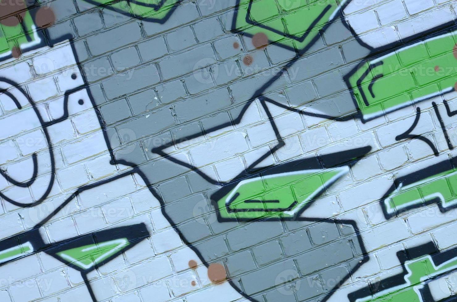 Fragment of graffiti drawings. The old wall decorated with paint stains in the style of street art culture. Colored background texture in green tones photo