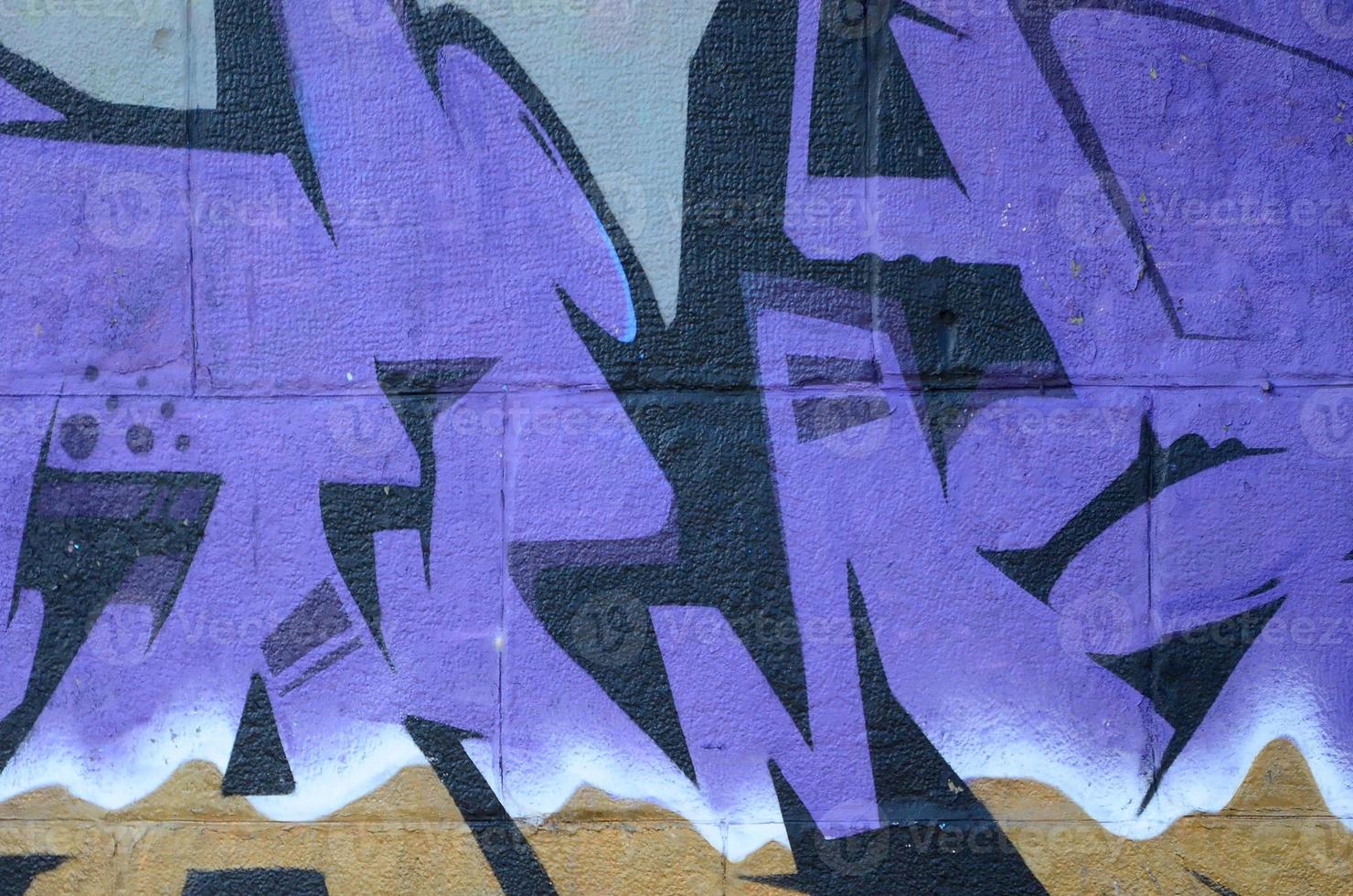 Fragment of graffiti drawings. The old wall decorated with paint stains in the style of street art culture. Colored background texture in purple tones photo