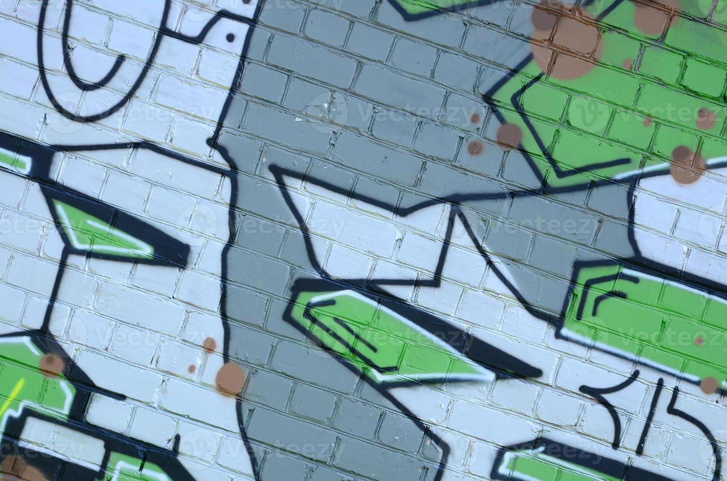Fragment of graffiti drawings. The old wall decorated with paint stains in the style of street art culture. Colored background texture in green tones photo