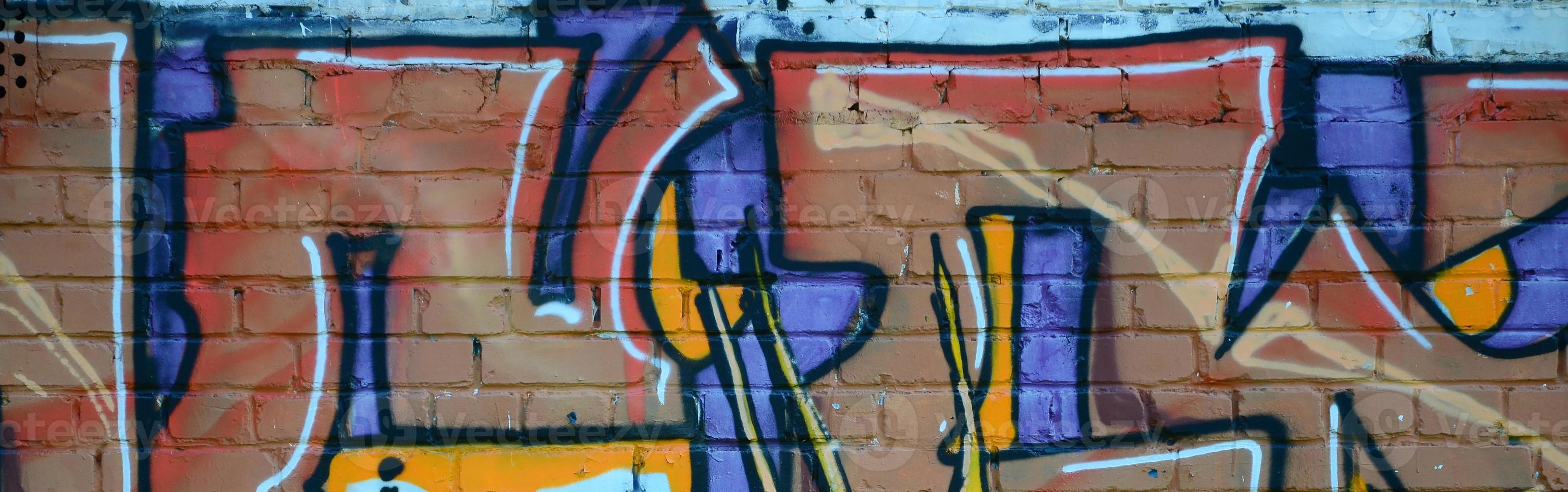 Fragment of graffiti drawings. The old wall decorated with paint stains in the style of street art culture. Colored background texture in warm tones photo