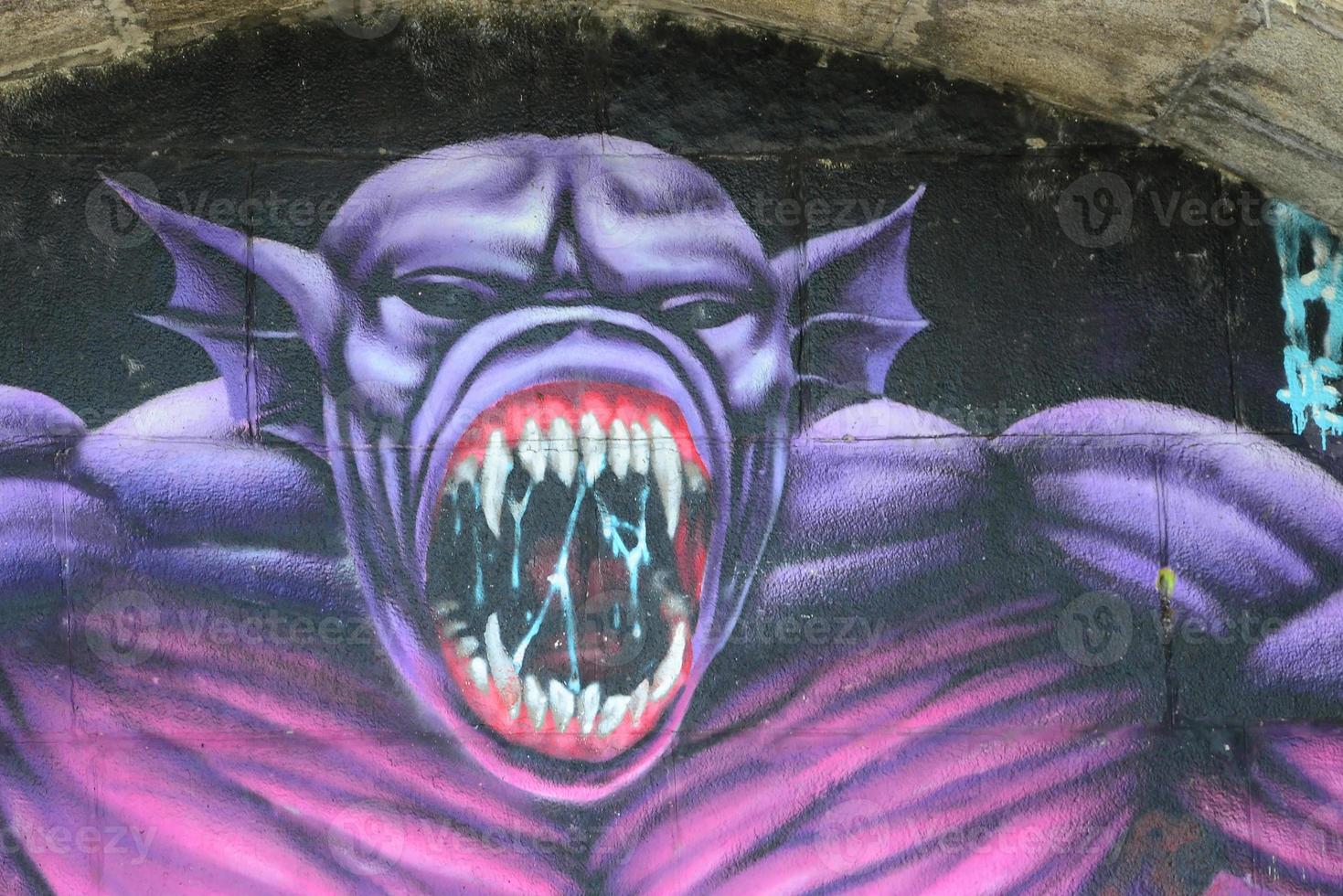 fragmento de dibujos de graffiti. la antigua muralla decorada con manchas de pintura al estilo de la cultura del arte callejero. monstruo aterrador púrpura foto