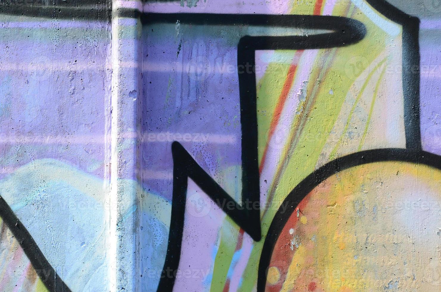Fragment of graffiti drawings. The old wall decorated with paint stains in the style of street art culture. Multicolored background texture photo