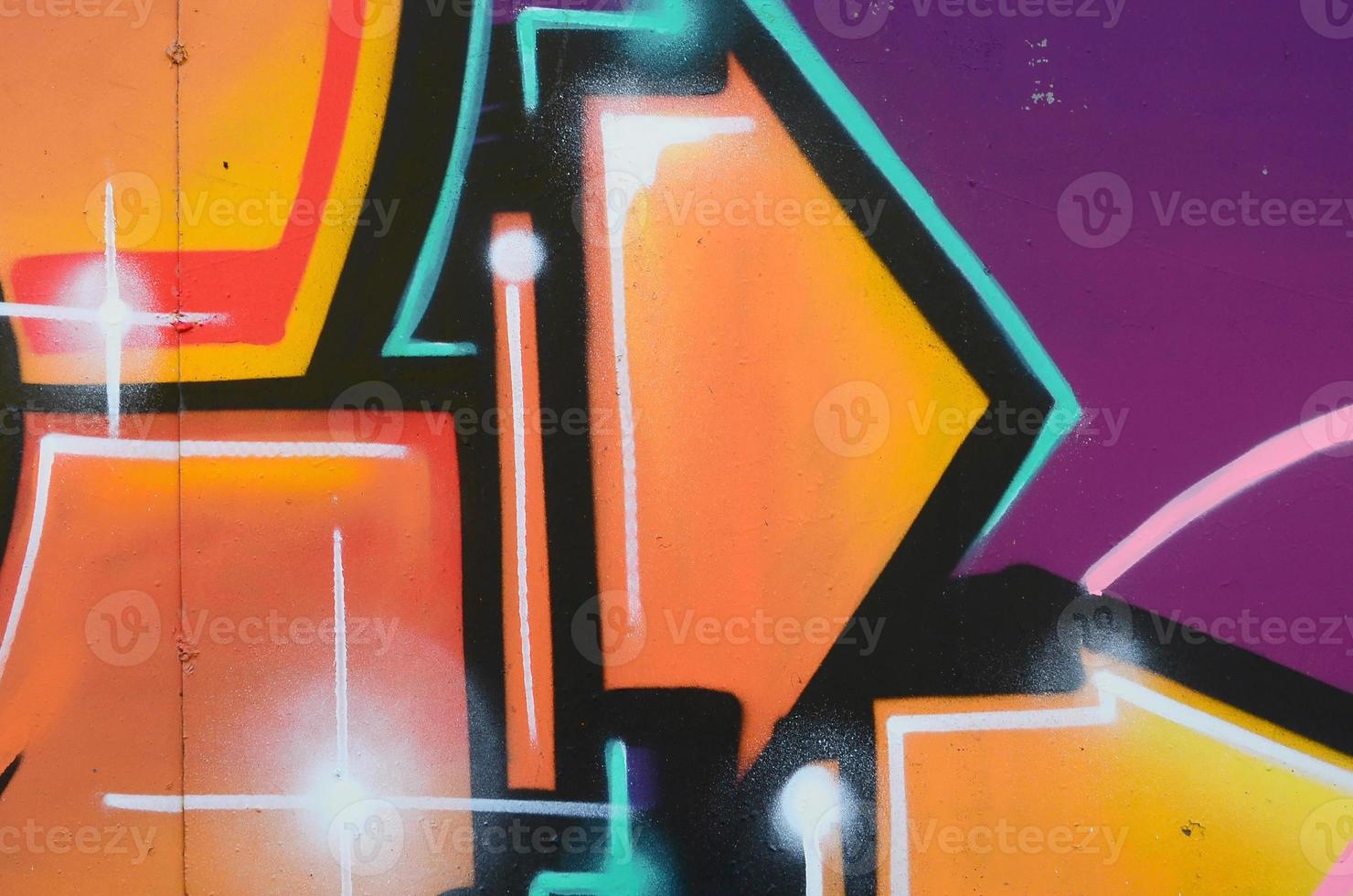 Fragment of graffiti drawings. The old wall decorated with paint stains in the style of street art culture. Colored background texture in warm tones photo