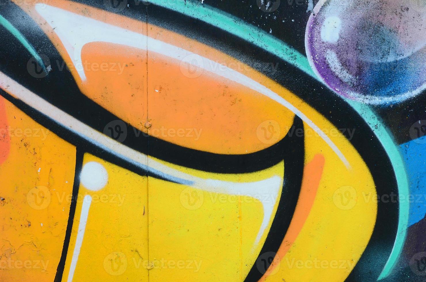 Fragment of graffiti drawings. The old wall decorated with paint stains in the style of street art culture. Colored background texture in warm tones photo