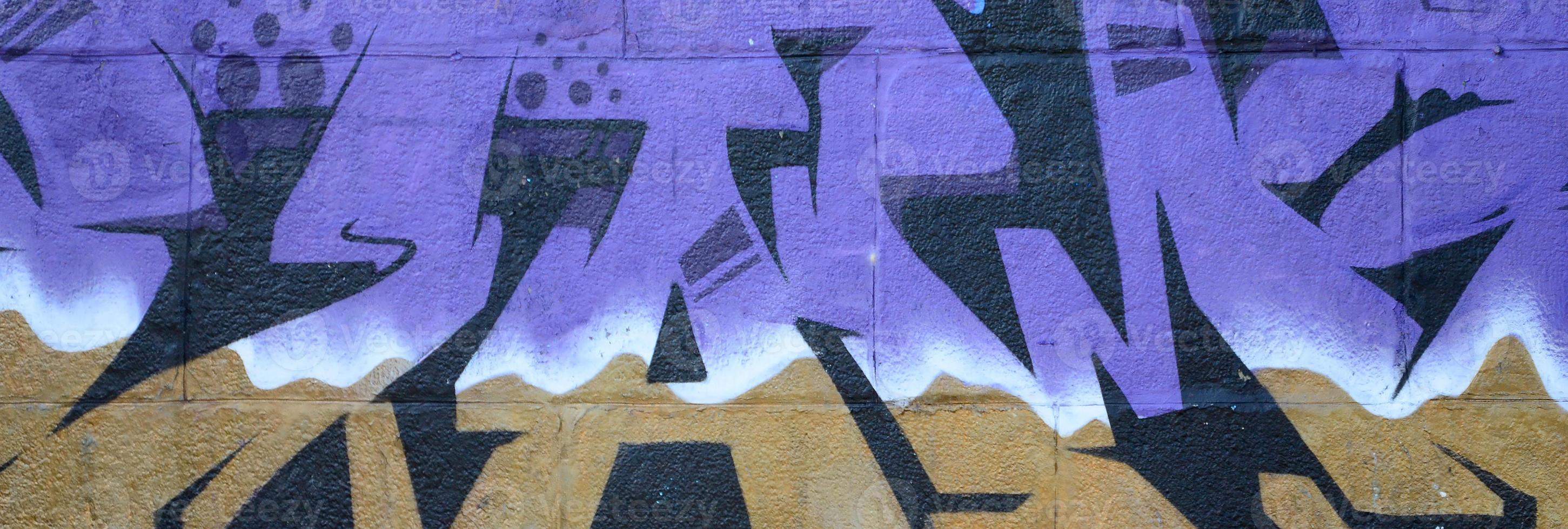 fragmento de dibujos de graffiti. la antigua muralla decorada con manchas de pintura al estilo de la cultura del arte callejero. textura de fondo coloreada en tonos morados foto