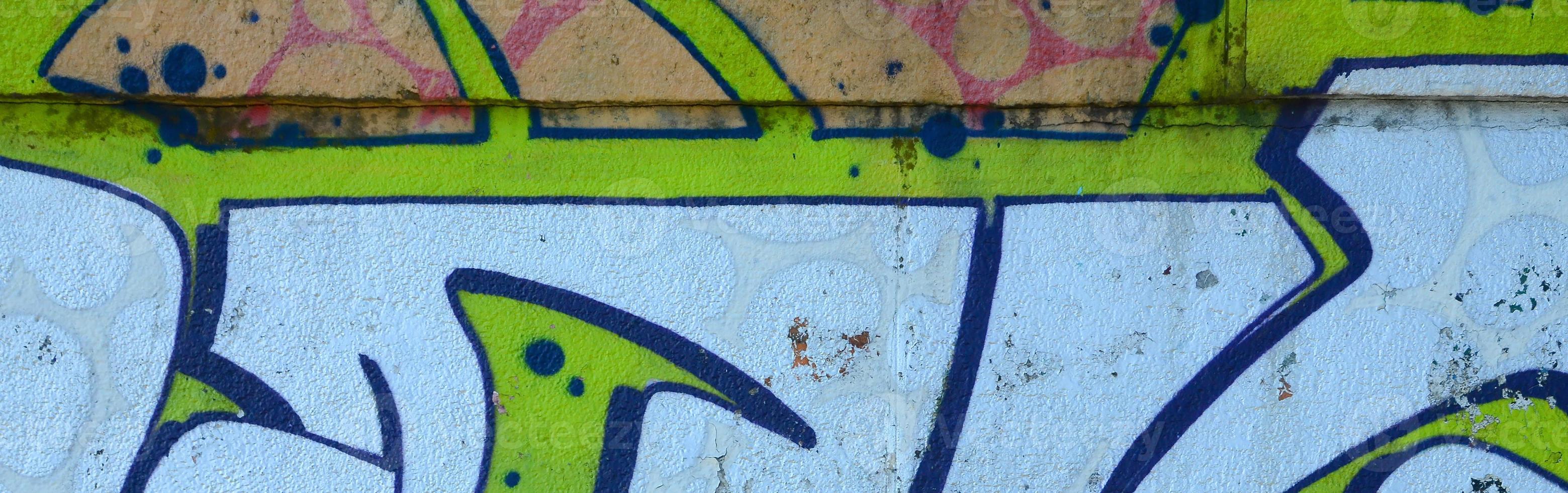 Fragment of graffiti drawings. The old wall decorated with paint stains in the style of street art culture. Colored background texture in green tones photo