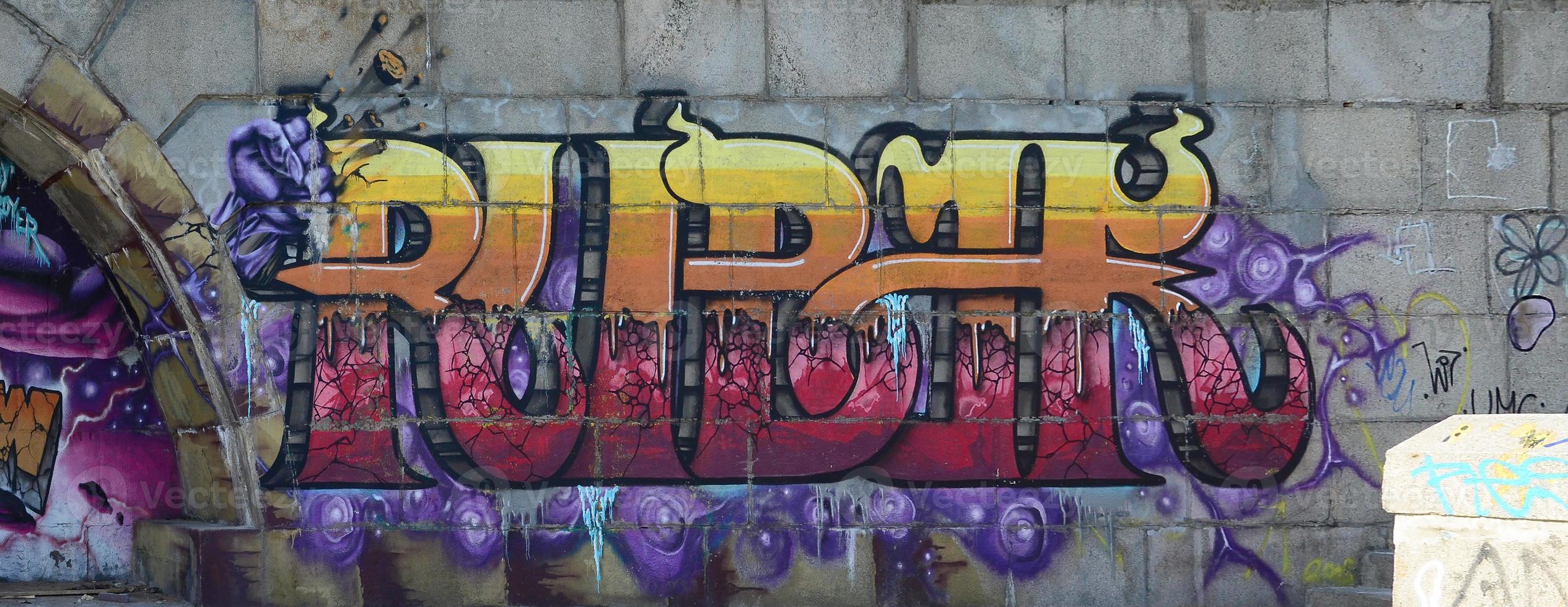 Fragment of graffiti drawings. The old wall decorated with paint stains in the style of street art culture. Colored background texture in warm tones photo