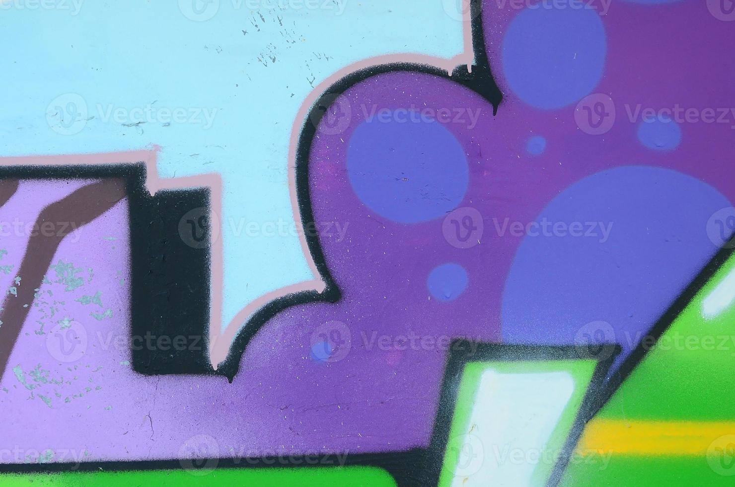 Fragment of graffiti drawings. The old wall decorated with paint stains in the style of street art culture. Multicolored background texture photo