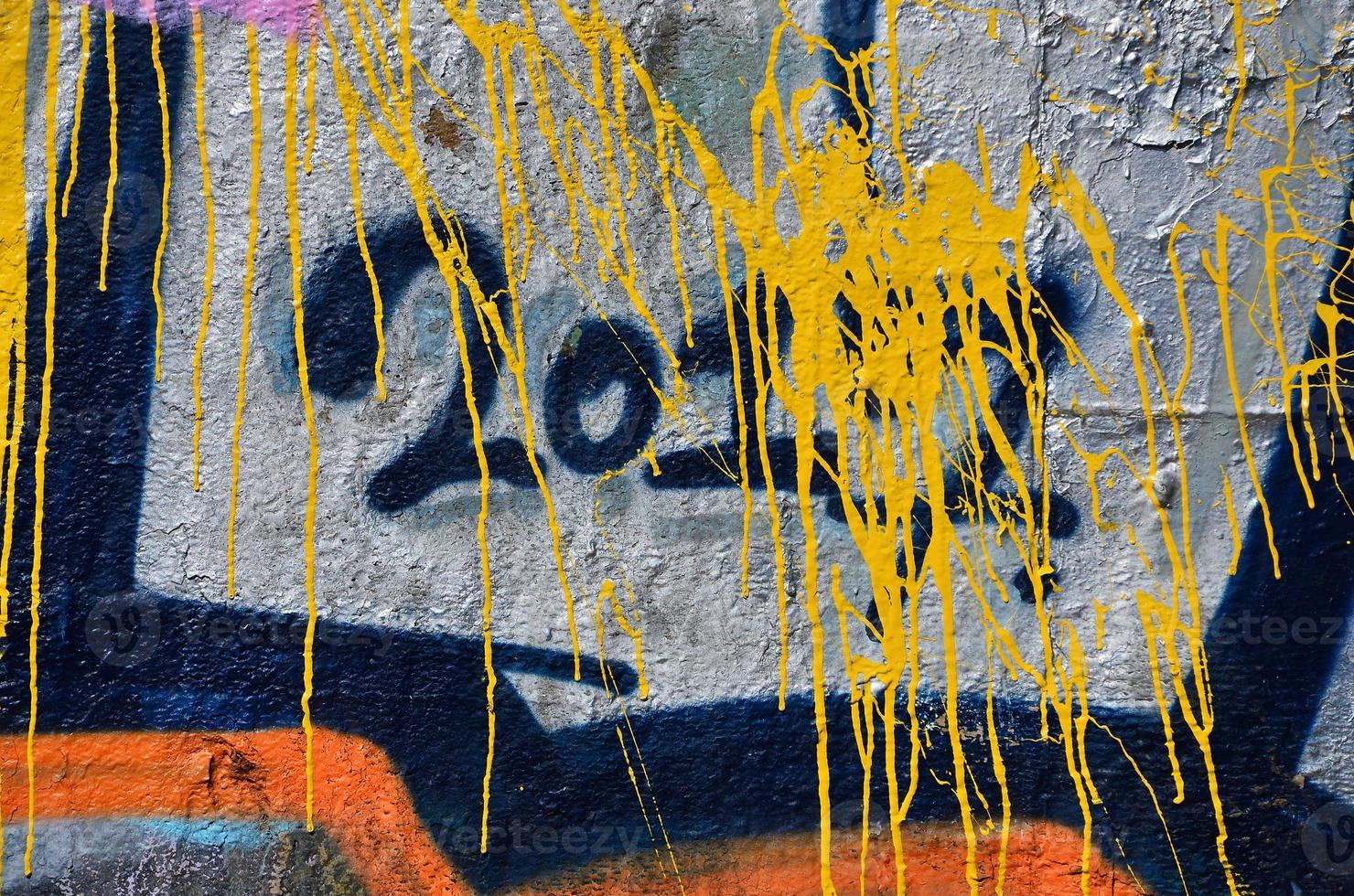 Fragment of an old colored graffiti drawing on the wall. Background image as an illustration of street art, vandalism and wall painting with aerosol paint photo