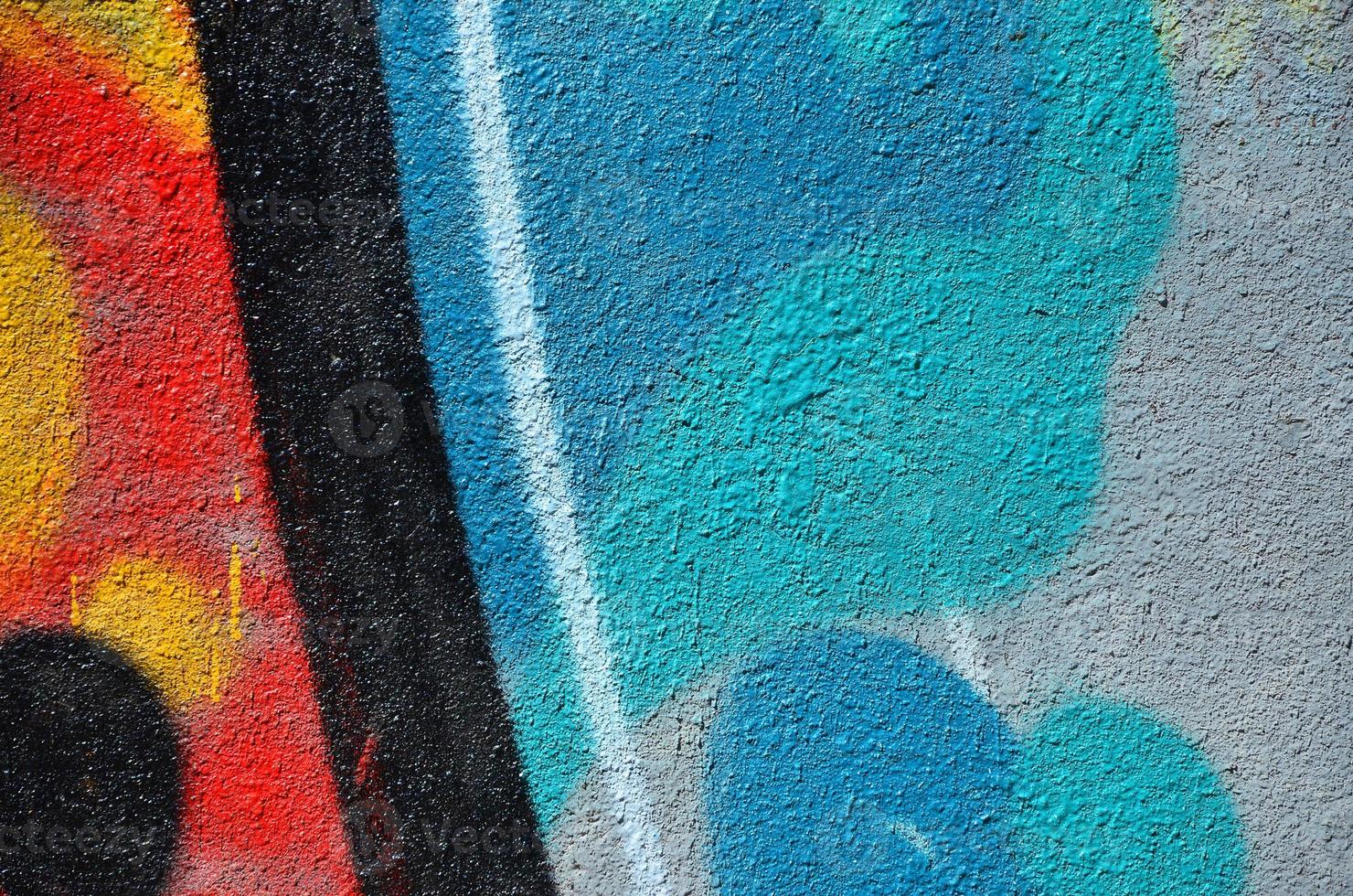 Fragment of an old colored graffiti drawing on the wall. Background image as an illustration of street art, vandalism and wall painting with aerosol paint photo