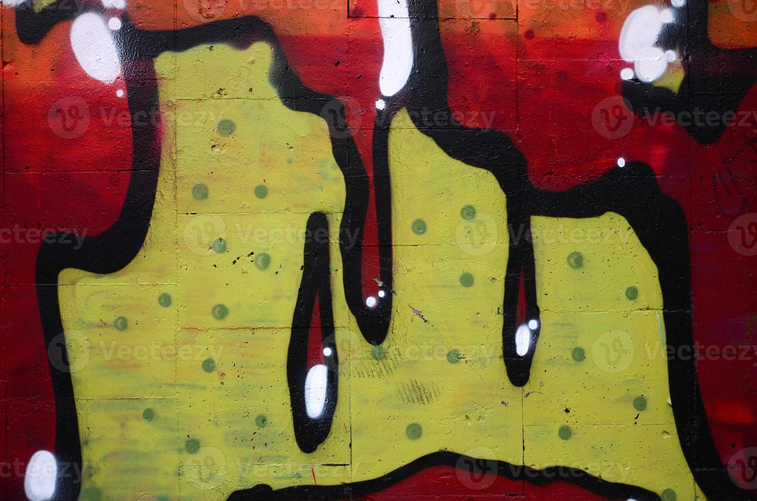 A fragment of graffiti drawing using contours, applied to the wall with the help of cans with aerosol paints over the colored filling areas. Background texture of street art and vandalism photo