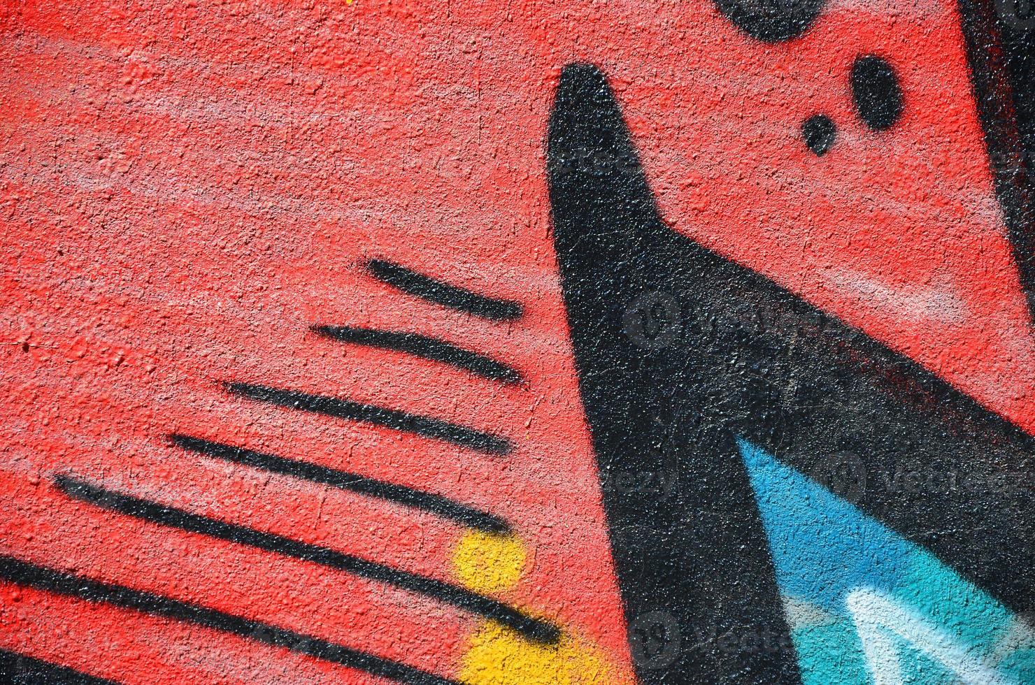 Fragment of an old colored graffiti drawing on the wall. Background image as an illustration of street art, vandalism and wall painting with aerosol paint photo