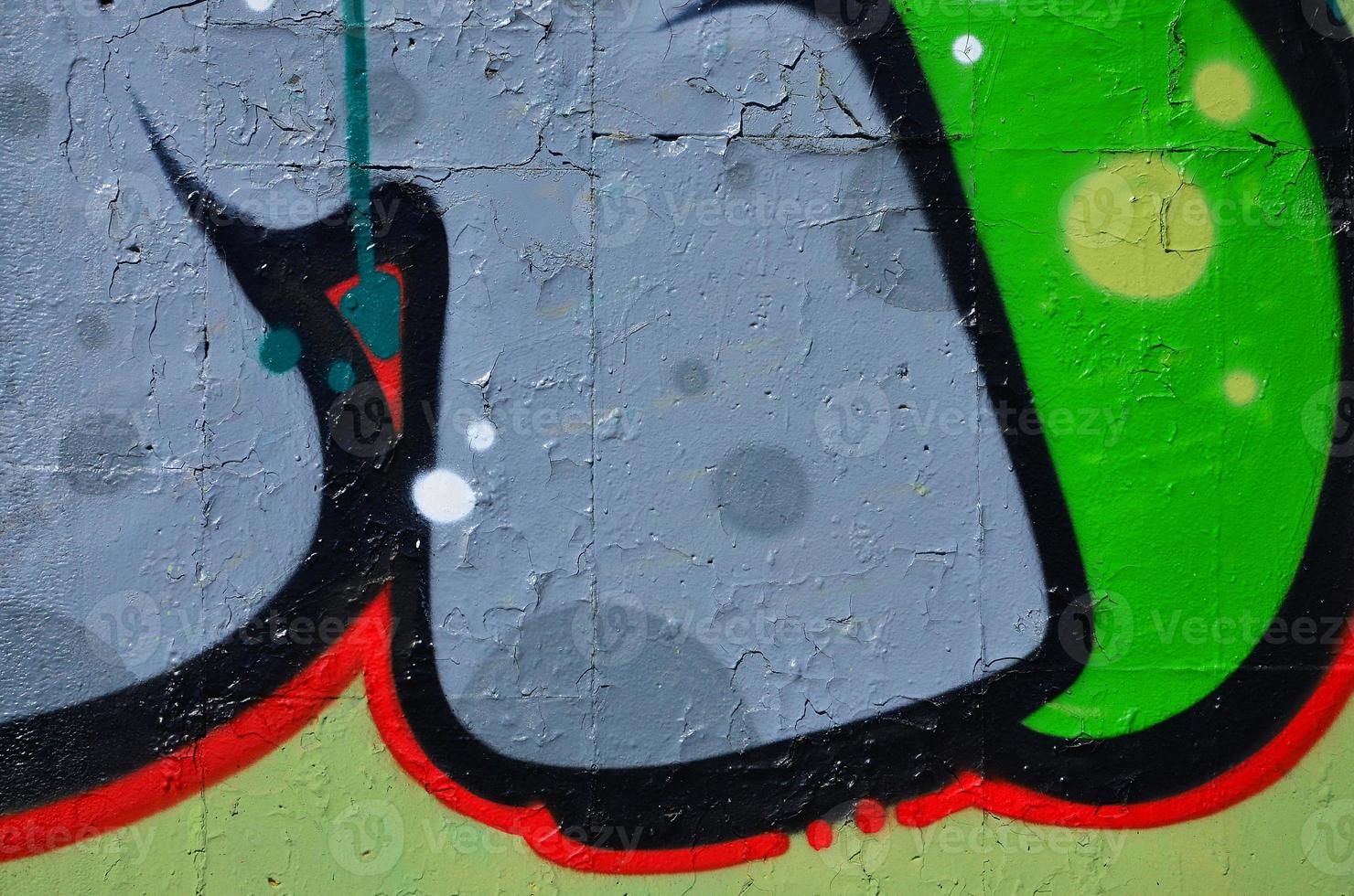 Fragment of an old colored graffiti drawing on the wall. Background image as an illustration of street art, vandalism and wall painting with aerosol paint photo