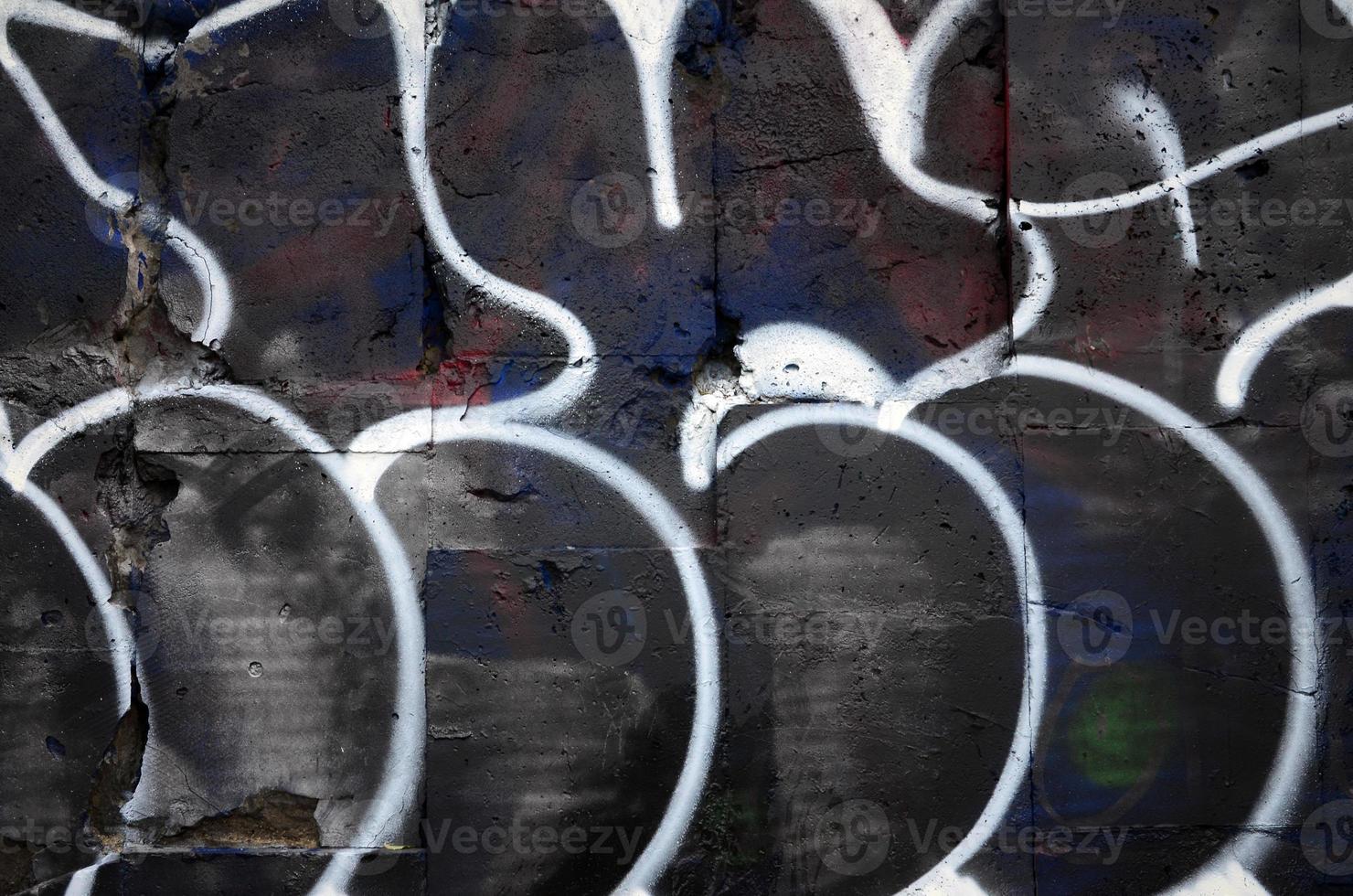 A fragment of graffiti drawing using contours, applied to the wall with the help of cans with aerosol paints over the colored filling areas. Background texture of street art and vandalism photo