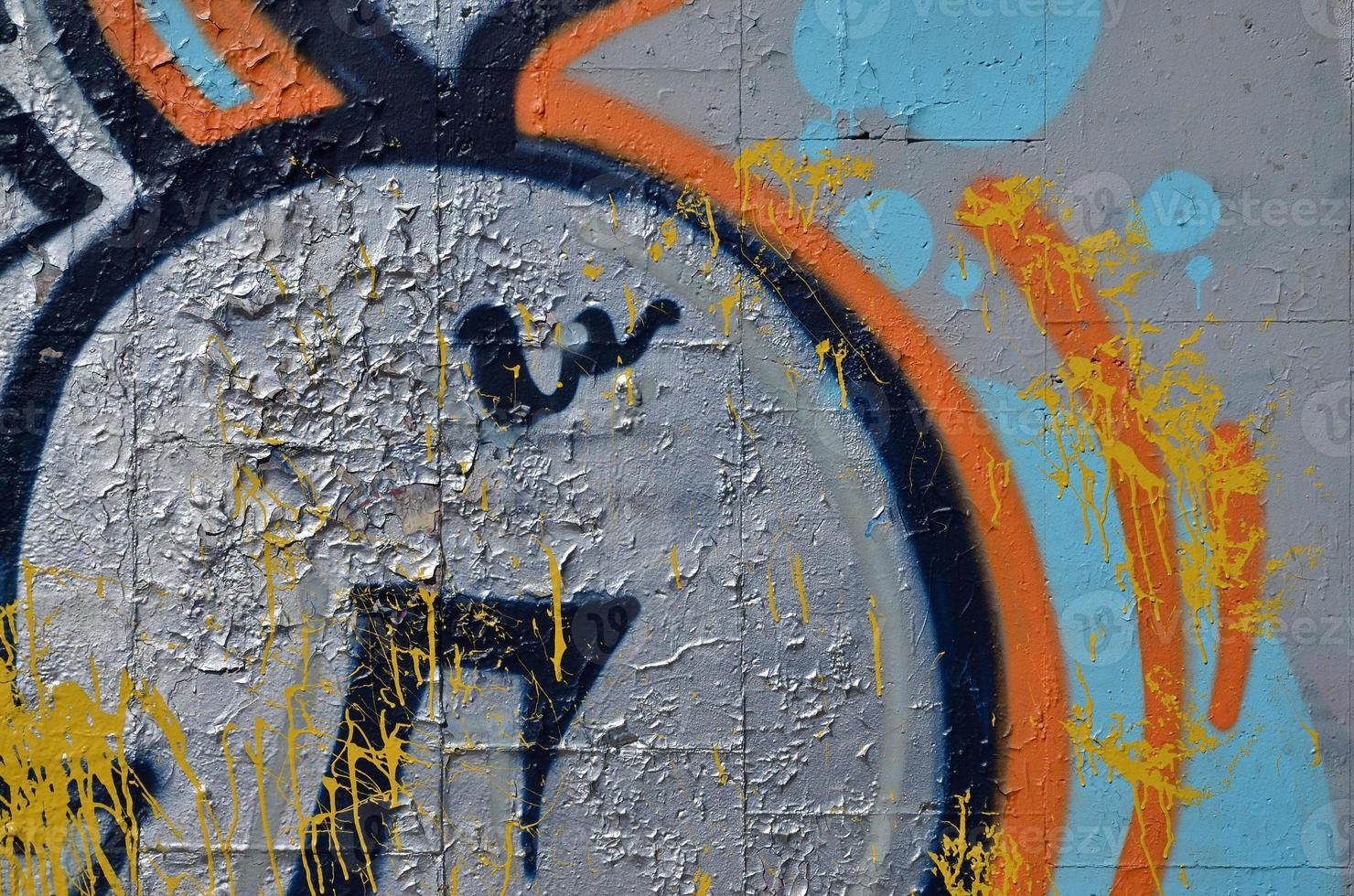 Fragment of an old colored graffiti drawing on the wall. Background image as an illustration of street art, vandalism and wall painting with aerosol paint photo