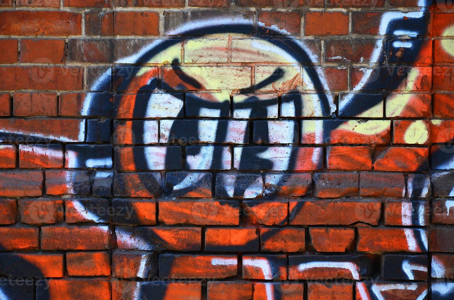 Fragment of an old colored graffiti drawing on the wall. Background image as an illustration of street art, vandalism and wall painting with aerosol paint photo