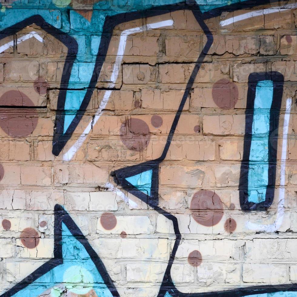 Fragment of graffiti drawings. The old wall decorated with paint stains in the style of street art culture. Colored background texture photo
