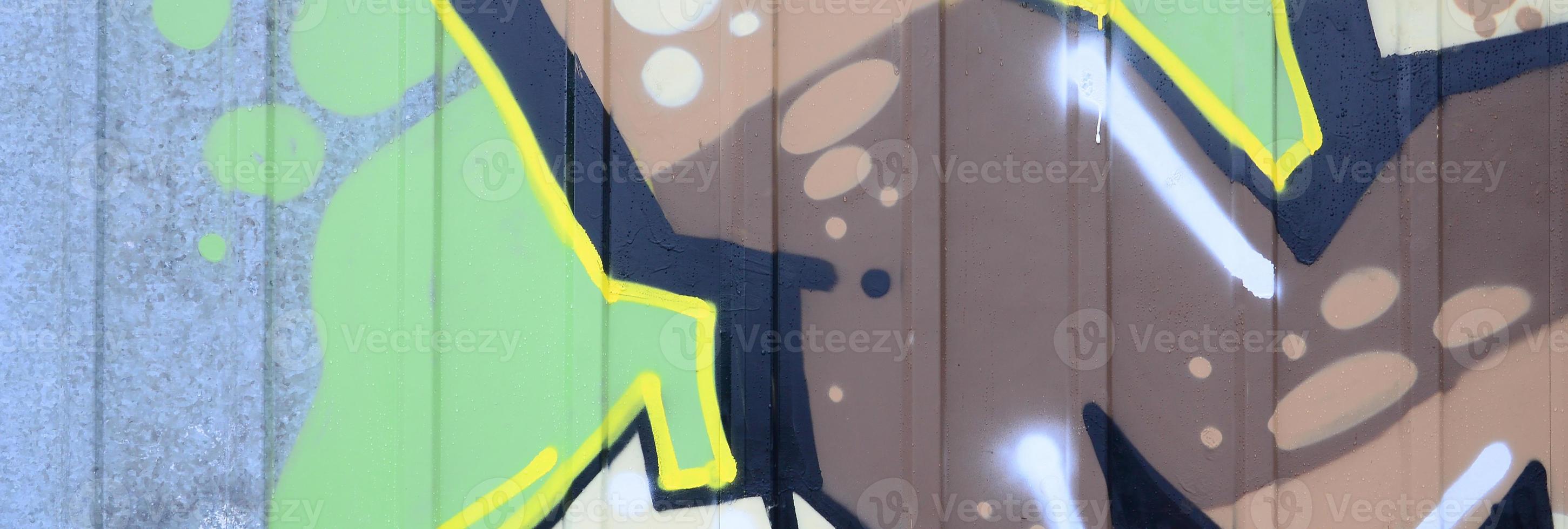 Fragment of graffiti drawings. The old wall decorated with paint stains in the style of street art culture. Colored background texture photo