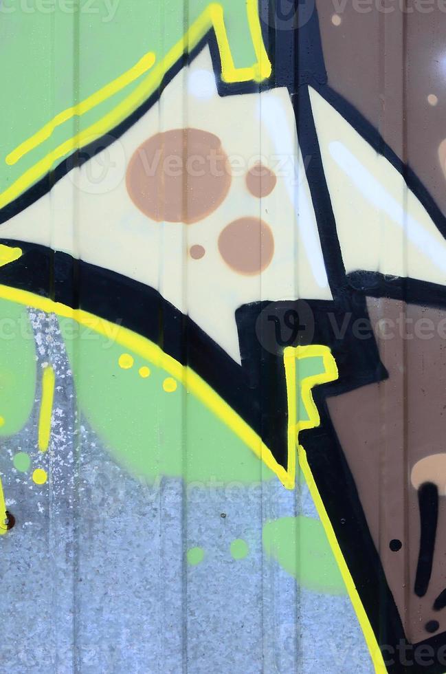 Fragment of graffiti drawings. The old wall decorated with paint stains in the style of street art culture. Colored background texture photo