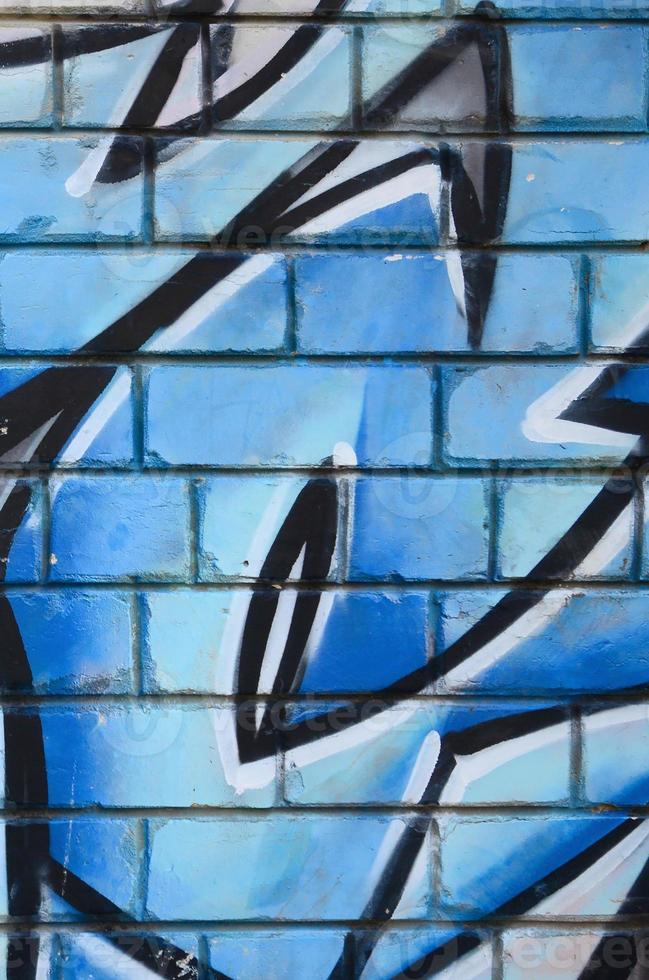Fragment of graffiti drawings. The old wall decorated with paint stains in the style of street art culture. Colored background texture photo