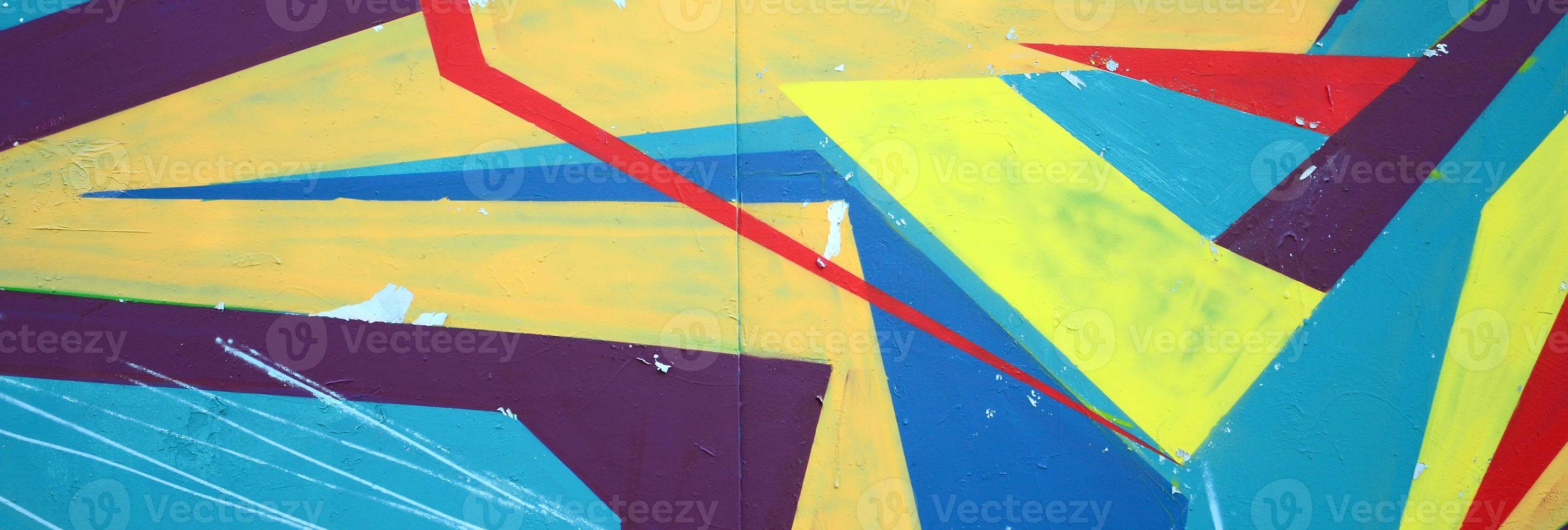 Fragment of graffiti drawings. The old wall decorated with paint stains in the style of street art culture. Colored background texture photo