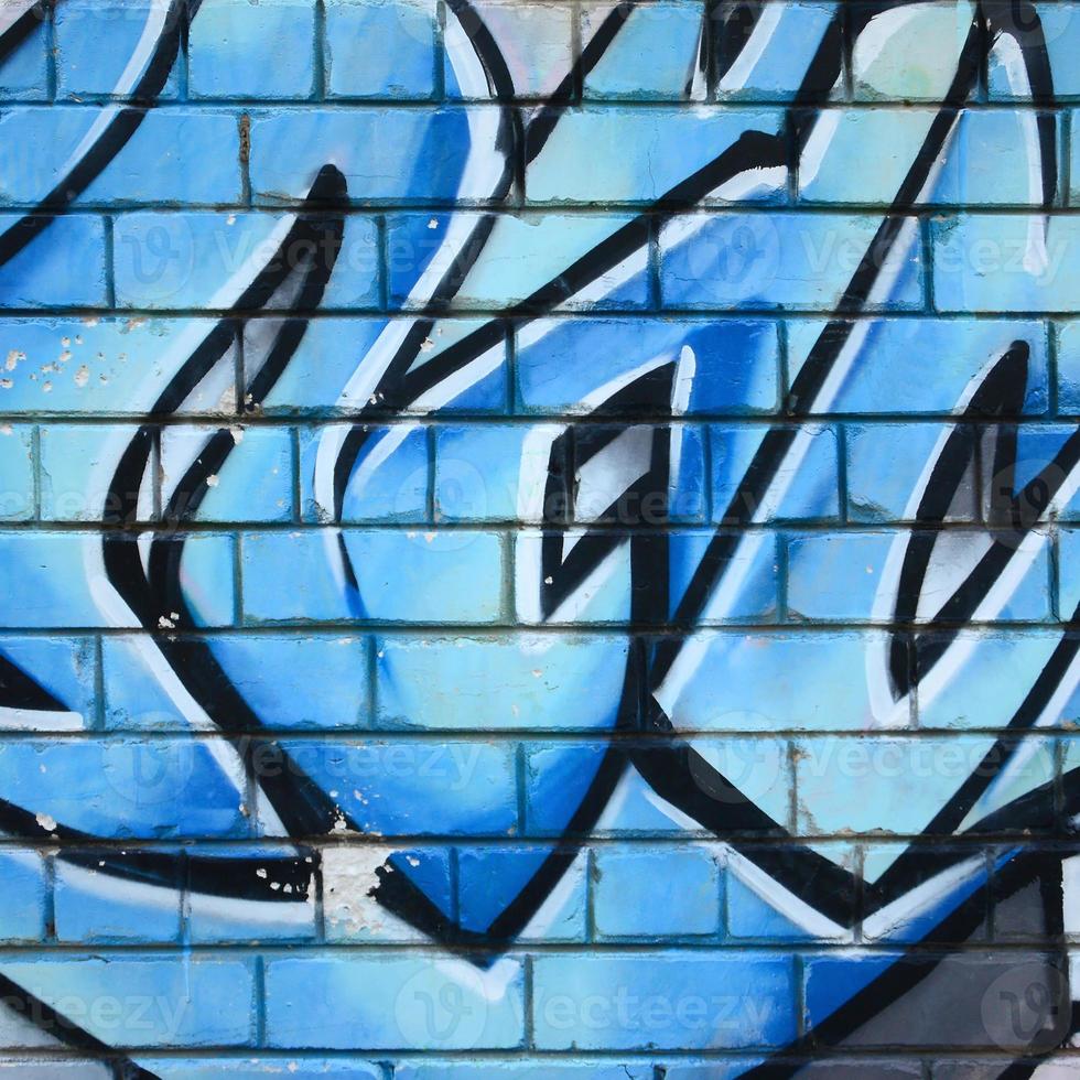Fragment of graffiti drawings. The old wall decorated with paint stains in the style of street art culture. Colored background texture photo