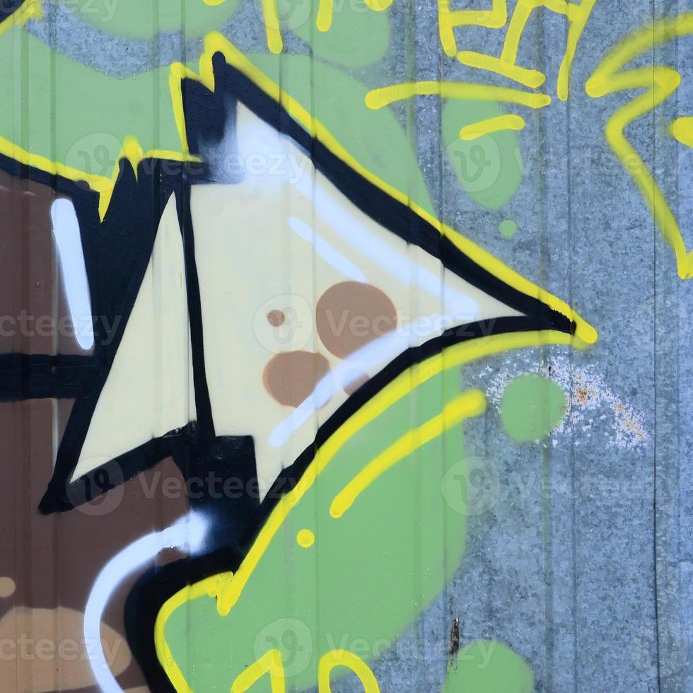 Fragment of graffiti drawings. The old wall decorated with paint stains in the style of street art culture. Colored background texture photo