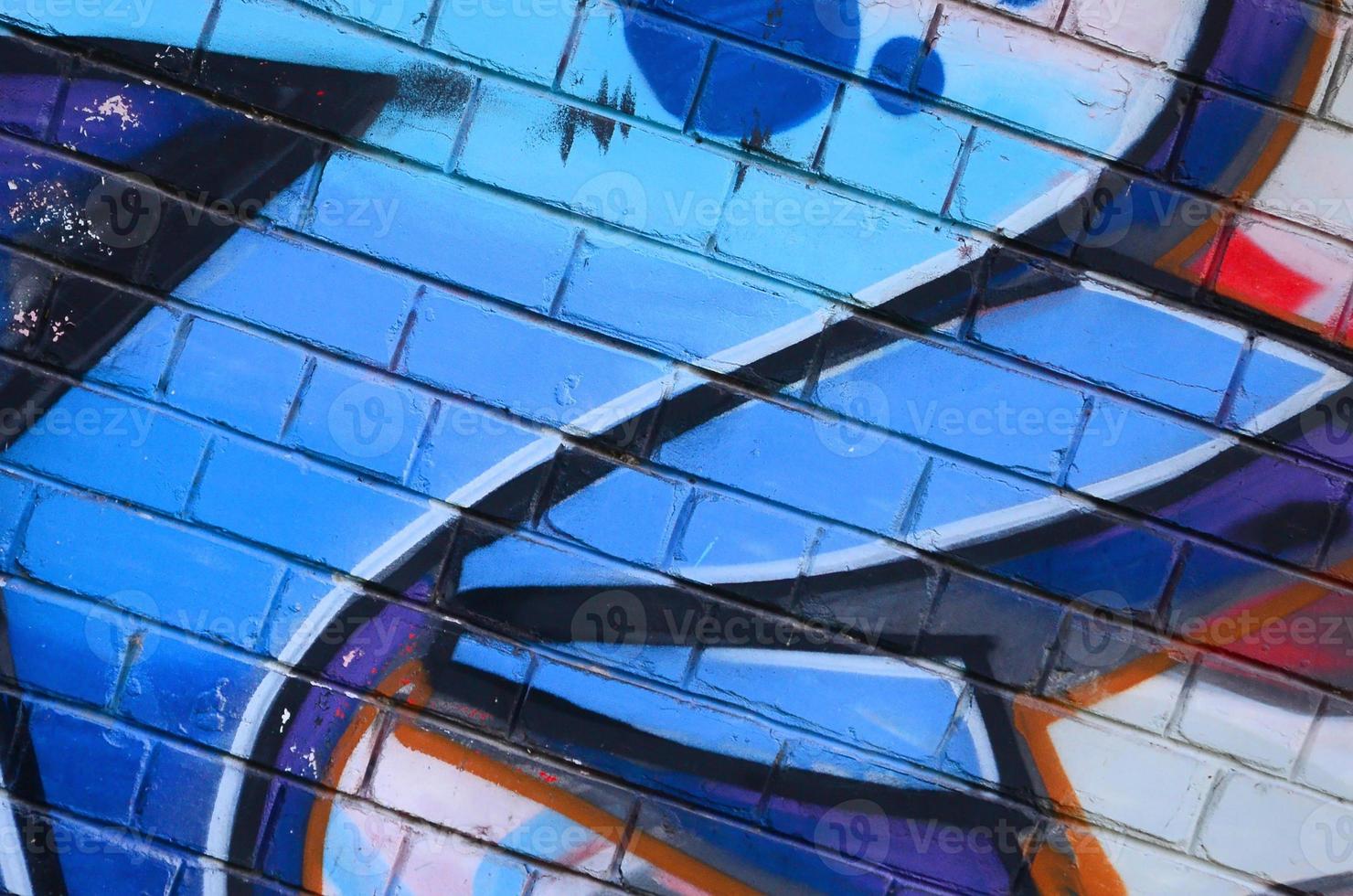 Fragment of graffiti drawings. The old wall decorated with paint stains in the style of street art culture. Colored background texture photo