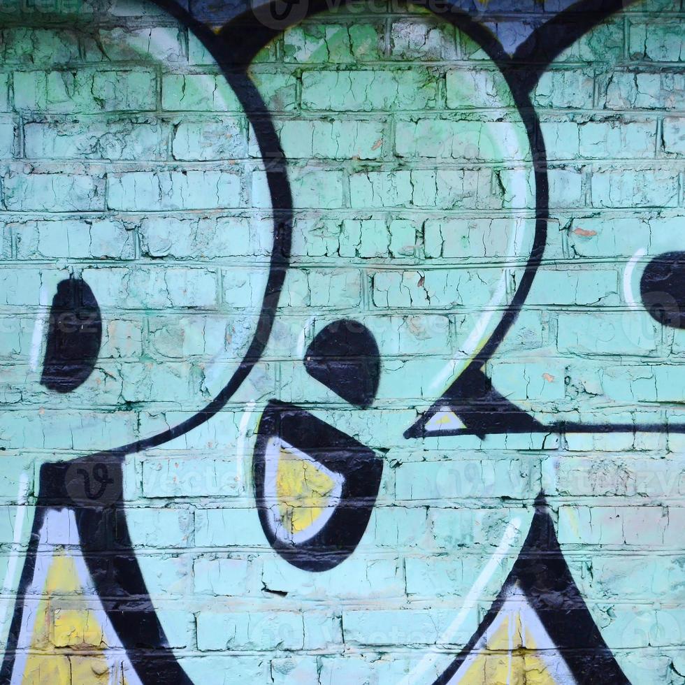 Fragment of graffiti drawings. The old wall decorated with paint stains in the style of street art culture. Colored background texture photo