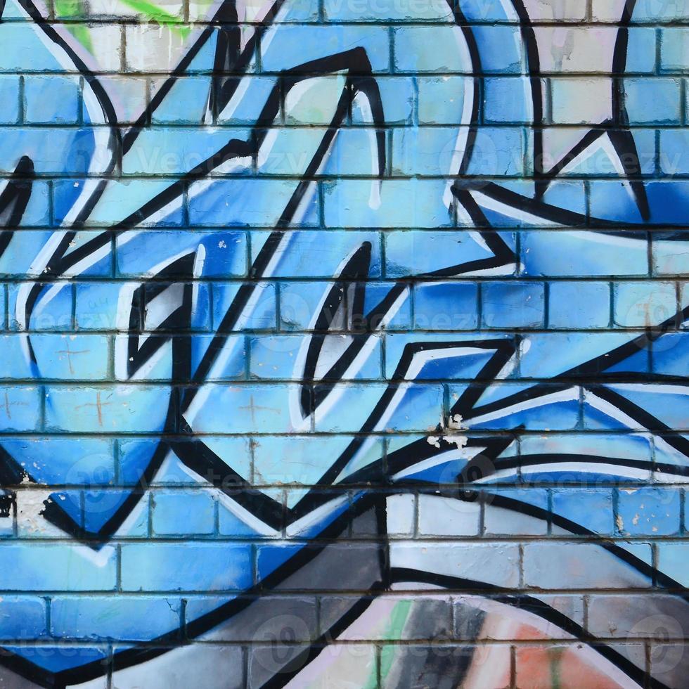 Fragment of graffiti drawings. The old wall decorated with paint stains in the style of street art culture. Colored background texture photo