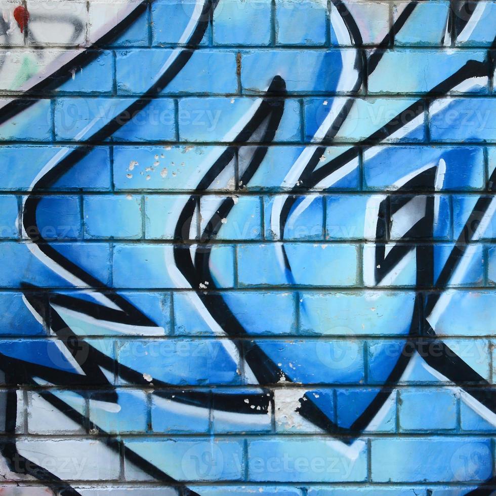 Fragment of graffiti drawings. The old wall decorated with paint stains in the style of street art culture. Colored background texture photo