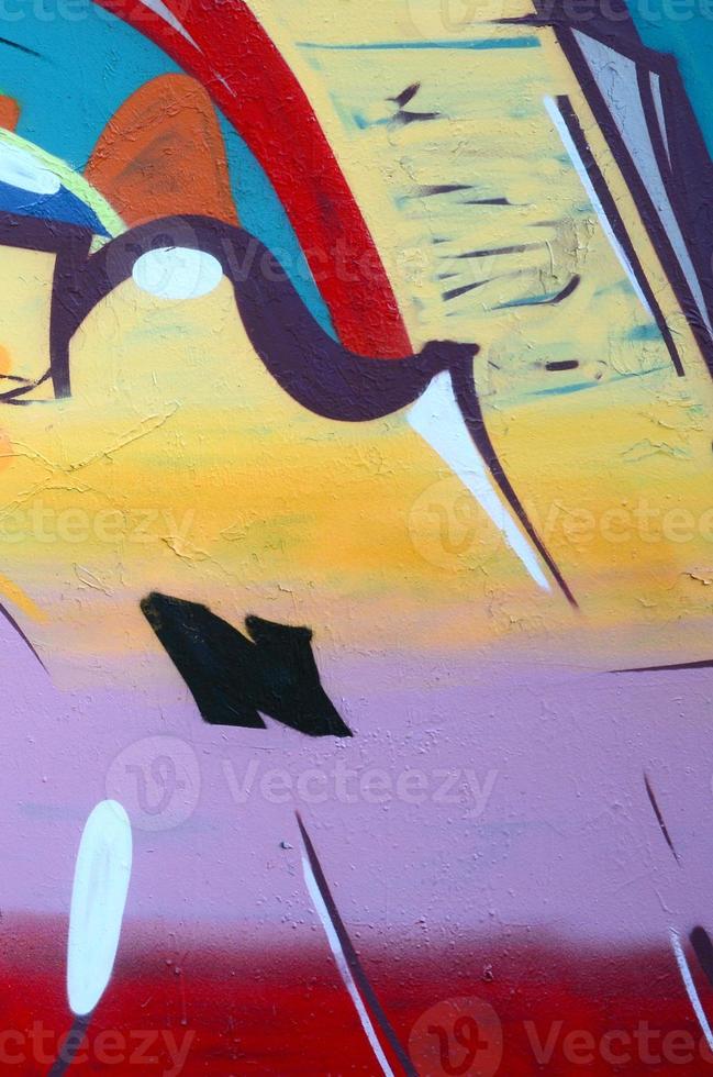 Fragment of graffiti drawings. The old wall decorated with paint stains in the style of street art culture. Colored background texture photo