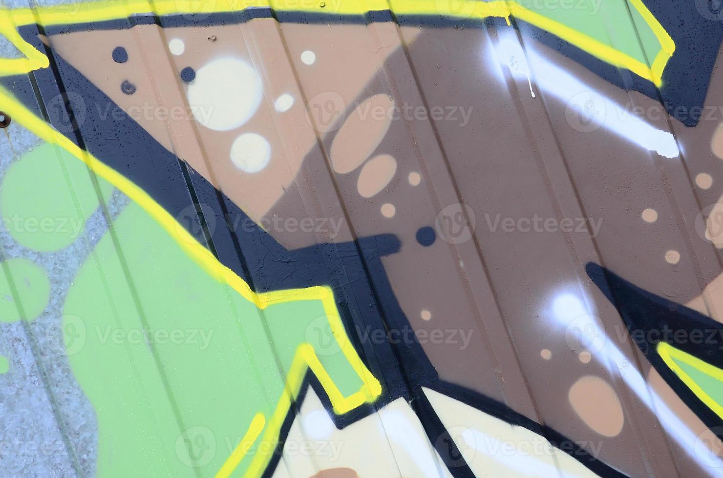 Fragment of graffiti drawings. The old wall decorated with paint stains in the style of street art culture. Colored background texture photo