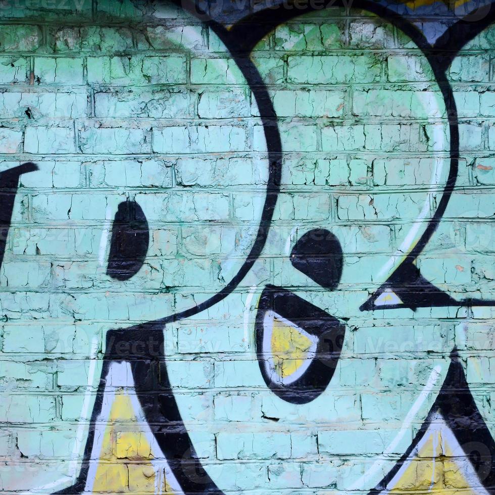 Fragment of graffiti drawings. The old wall decorated with paint stains in the style of street art culture. Colored background texture photo