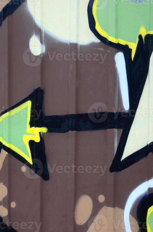 Fragment of graffiti drawings. The old wall decorated with paint stains in the style of street art culture. Colored background texture photo