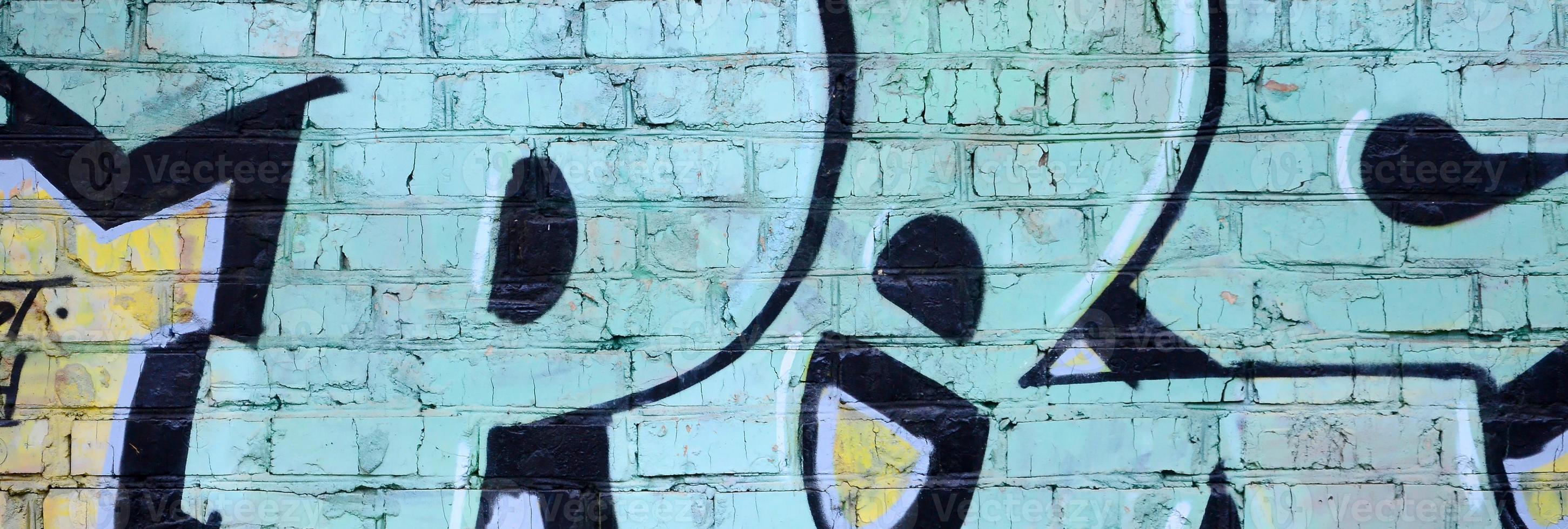 Fragment of graffiti drawings. The old wall decorated with paint stains in the style of street art culture. Colored background texture photo