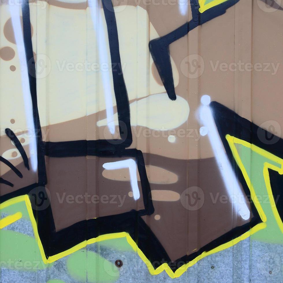 Fragment of graffiti drawings. The old wall decorated with paint stains in the style of street art culture. Colored background texture photo