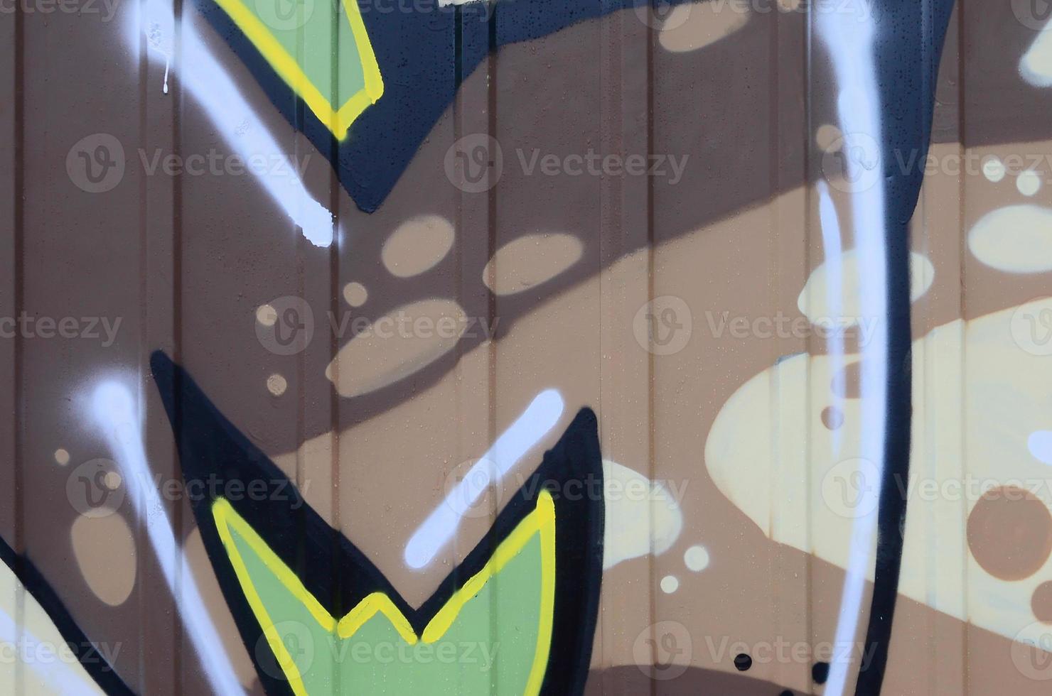 Fragment of graffiti drawings. The old wall decorated with paint stains in the style of street art culture. Colored background texture photo