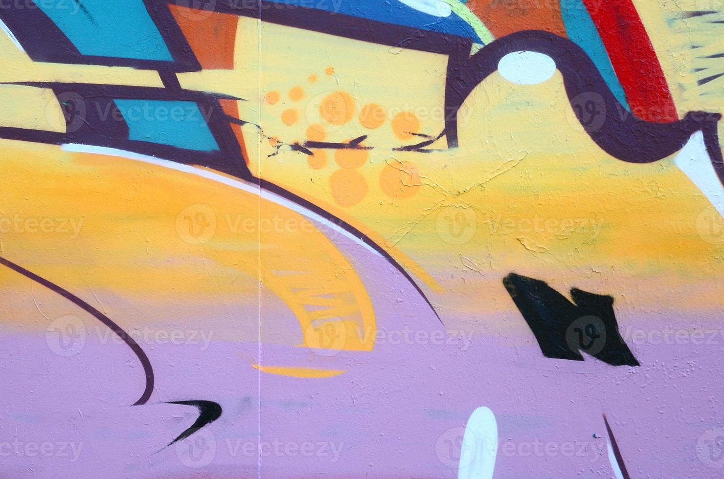 Fragment of graffiti drawings. The old wall decorated with paint stains in the style of street art culture. Colored background texture photo