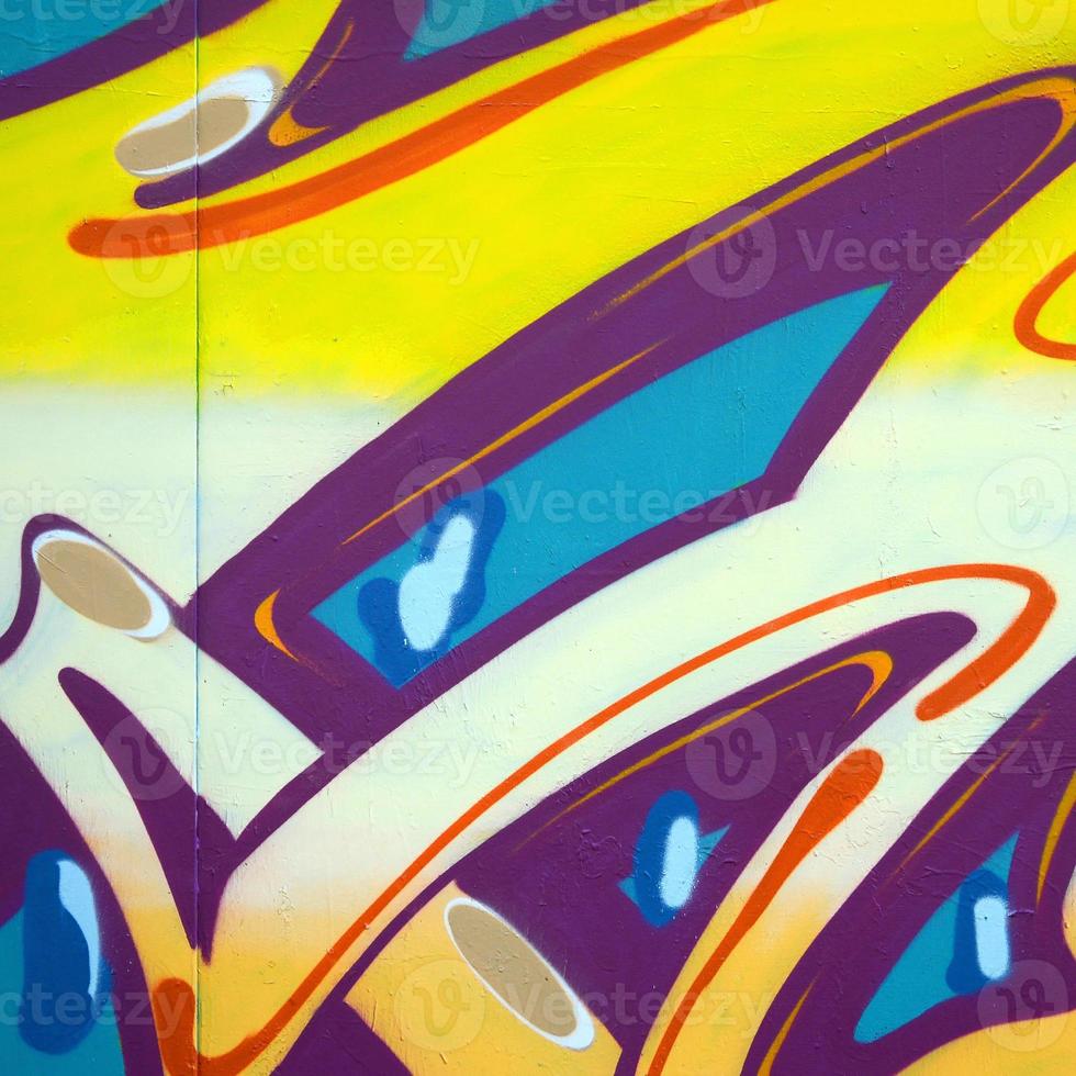 Fragment of graffiti drawings. The old wall decorated with paint stains in the style of street art culture. Colored background texture photo