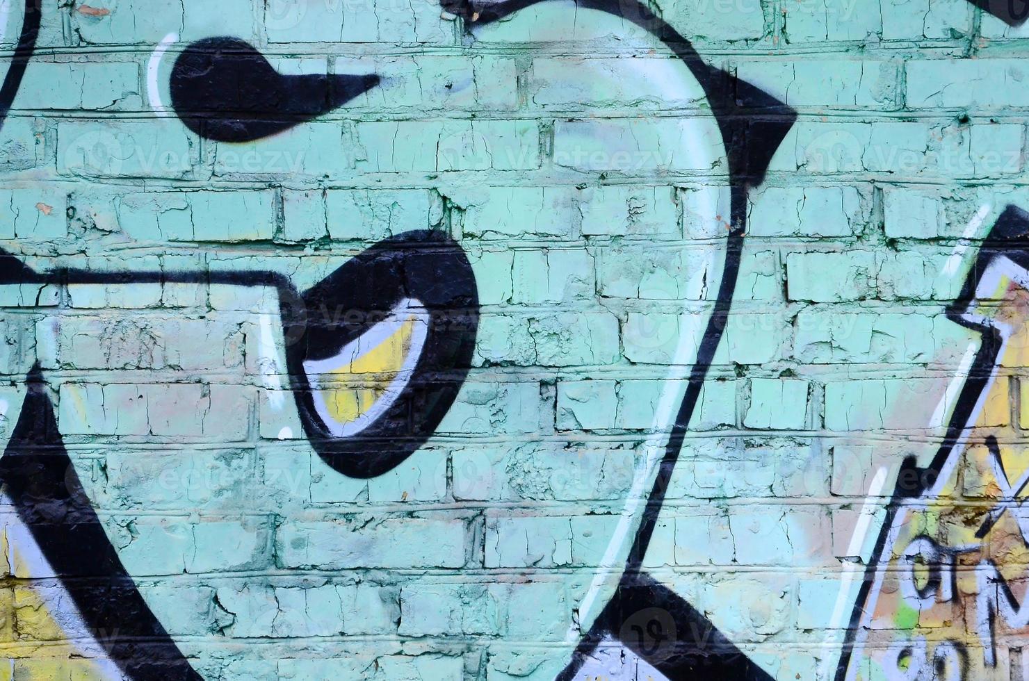 Fragment of graffiti drawings. The old wall decorated with paint stains in the style of street art culture. Colored background texture photo