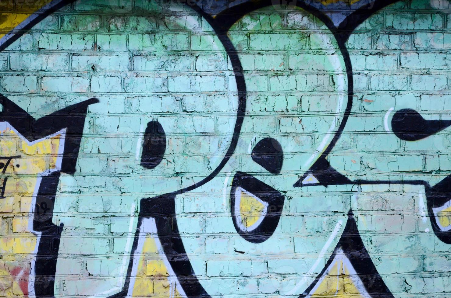 Fragment of graffiti drawings. The old wall decorated with paint stains in the style of street art culture. Colored background texture photo