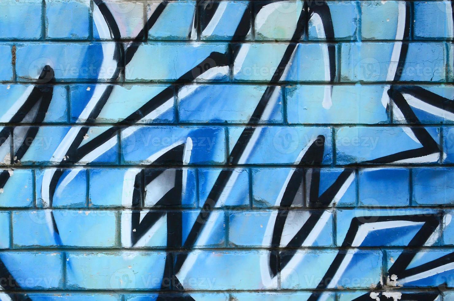 Fragment of graffiti drawings. The old wall decorated with paint stains in the style of street art culture. Colored background texture photo
