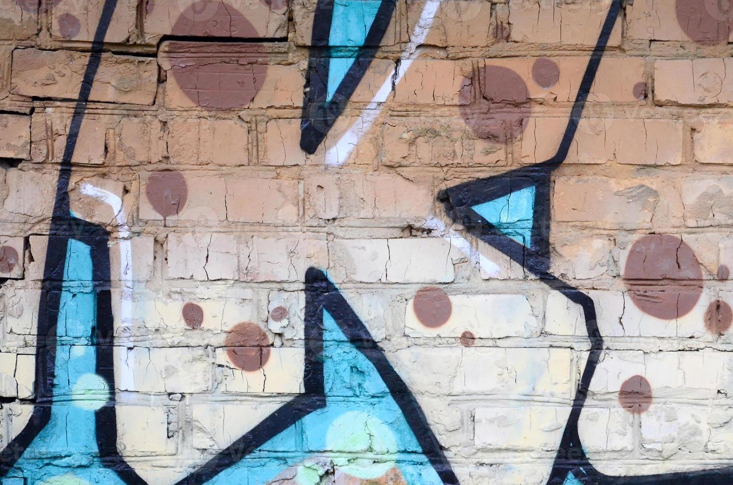 Fragment of graffiti drawings. The old wall decorated with paint stains in the style of street art culture. Colored background texture photo