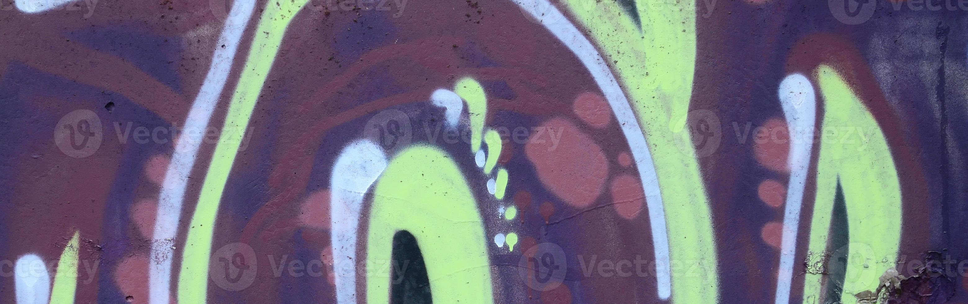 Fragment of graffiti drawings. The old wall decorated with paint stains in the style of street art culture. Colored background texture photo